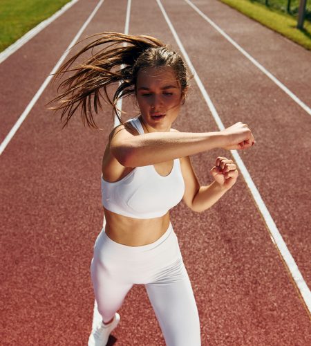 Practicing fight techniques. Young woman in sportive clothes is exercising outdoors